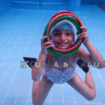niña realizando ejercicios en piscina